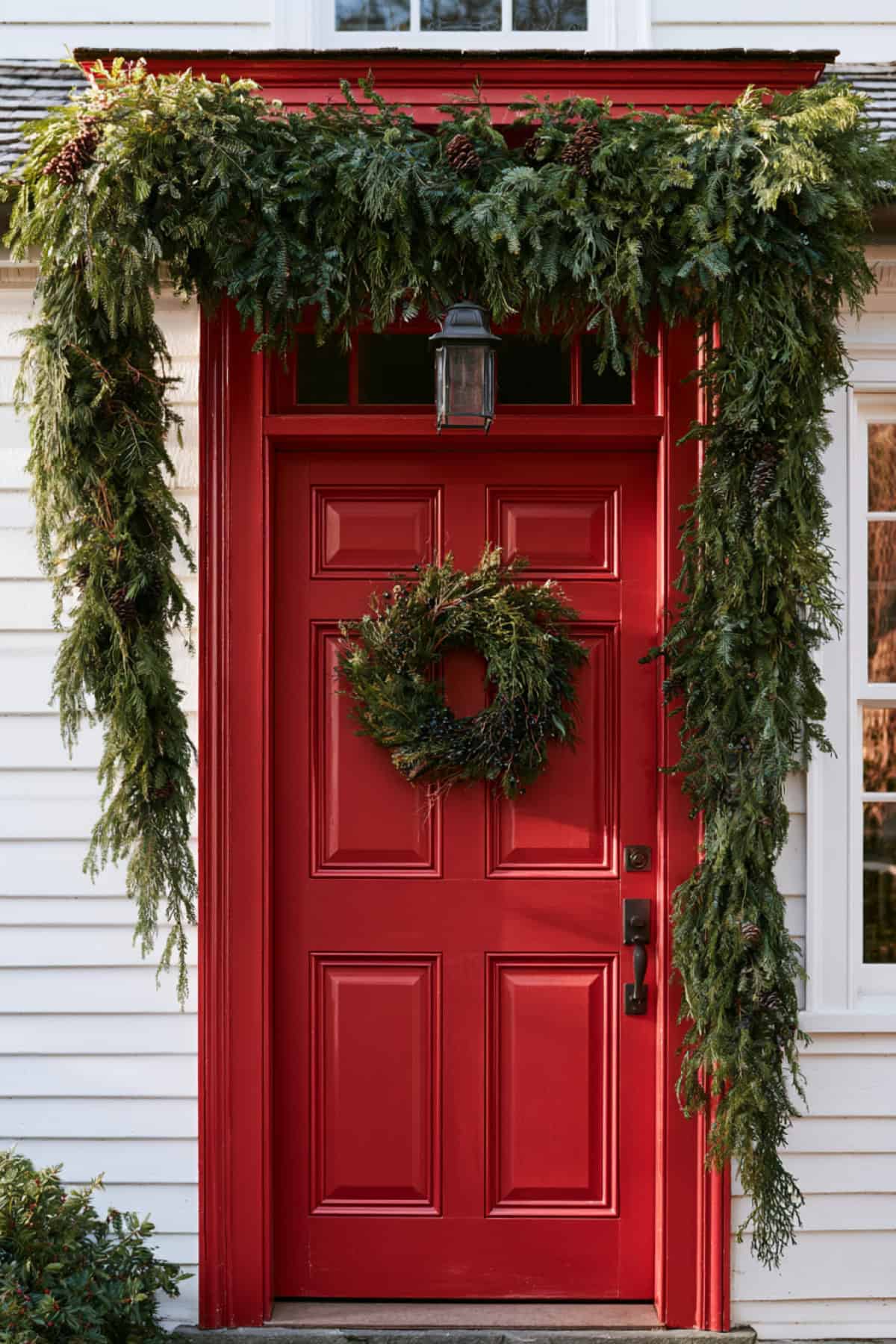 Cascading Greenery Above A Red Front Door
