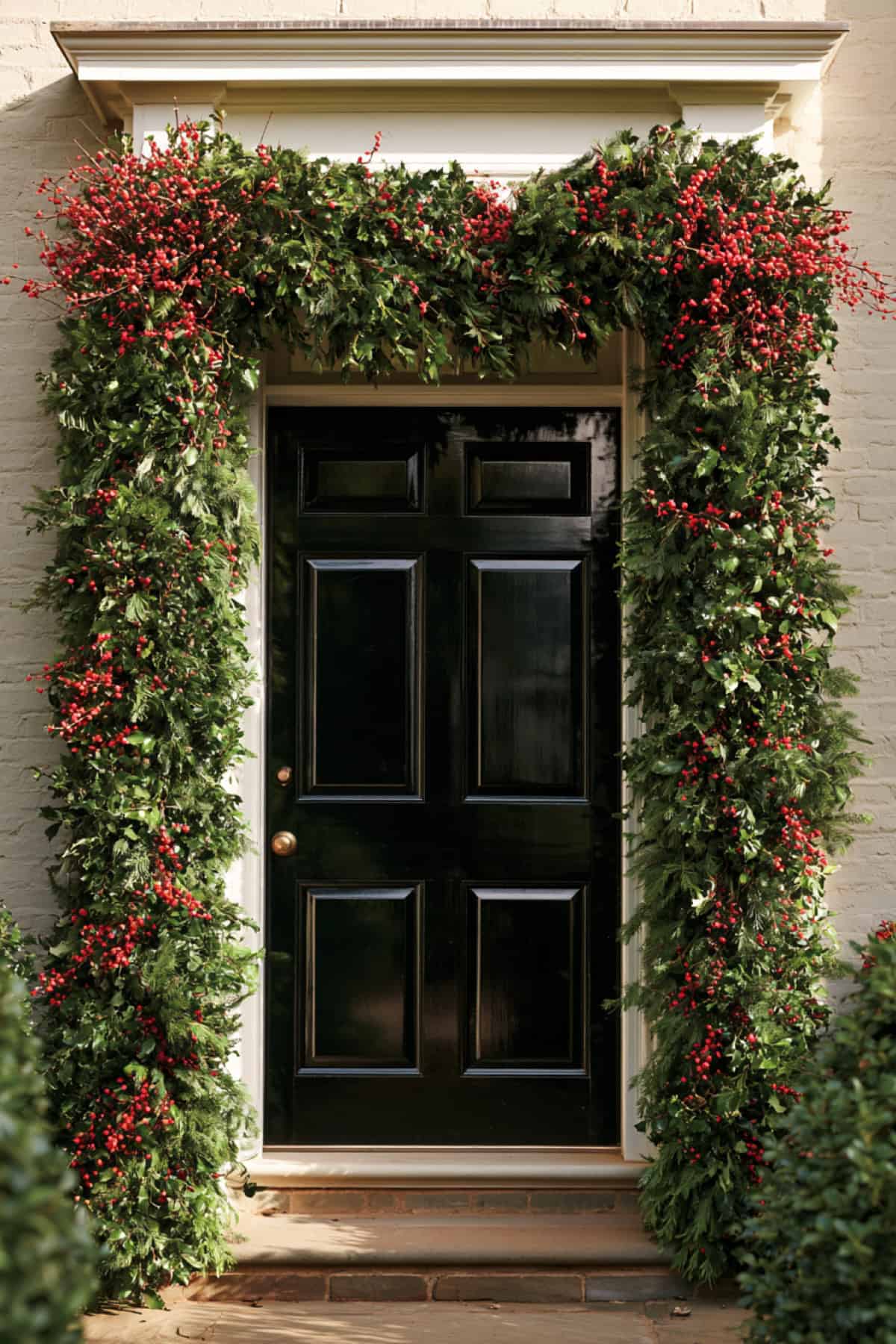 Greenery And Red Berry Arch Around The Front Door